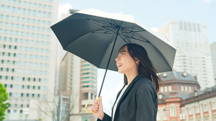 日傘をさして都市を歩く女性 © metamorworks