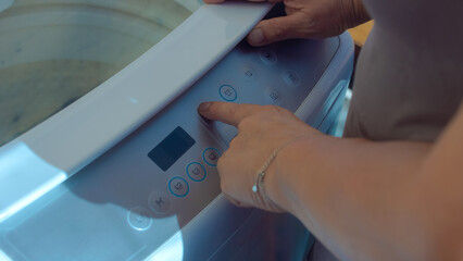 Pressing the buttons on the washing machine