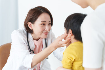 病院で子供の診察をする女性医師