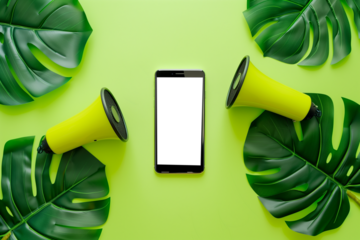 Top view of smartphone with blank screen and speaker on green background