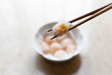 Dim sum for Chinese breakfast tea includes steamed shrimp dumplings served on a round plate with oiled paper.