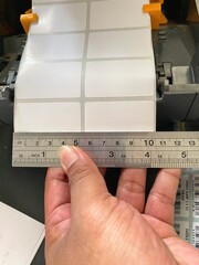 Someone is measuring print paper, which contains 2 coloumns. To prepare print product price. 