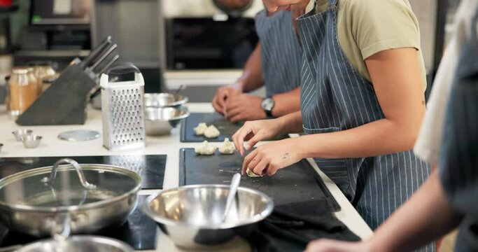Restaurant, kitchen and dumplings in hands of people cooking in class with food, dough or meal prep. Teamwork, collaboration and chef staff catering luxury menu in bakery with pastry to grill