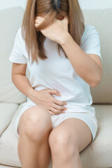 Obraz premium woman having abdomen ache due to Stomach pain, digestion with constipation or Diarrhea from food poisoning, female problem and Endometriosis, Hysterectomy, Stomachache and Menstrual on sofa at home