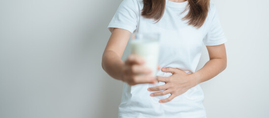 Lactose intolerance and Milk allergy concept. woman hold Milk glass and having abdominal cramps and...