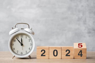 Happy New Year with vintage alarm clock and flipping 2024 change to 2025  block. Christmas, New...