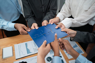 Corporate officer worker collaborate in office, connecting puzzle pieces with report paper on table...