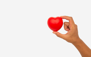 Fototapeta premium Hand holding a red heart-shaped object against a white background.