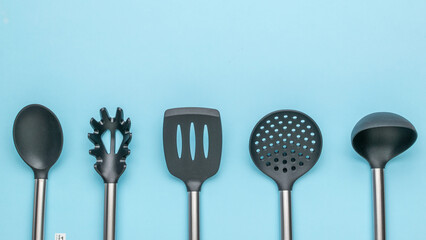 Set of Black Kitchen Utensils on Blue Background - Stylish Cooking Tools for Modern Kitchens