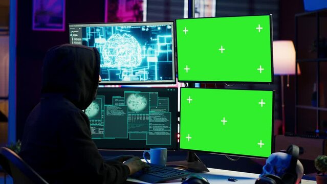 Rogue computer scientist uses AI deep learning and green screen PC to develop malware. Hacker uses artificial intelligence neural networks and chroma key monitors to build script, camera A