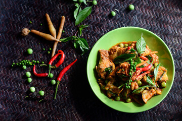 Top view of A spicy chicken stir-fry and chili in wooden background. Thai Food