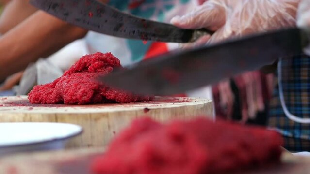 Chop beef finely using a sharp knife. Prepare steak tartare or chopped steak nearby.