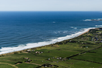 Aerial view of coastal landscape near Warrnambool, Victoria with ocean and green fields