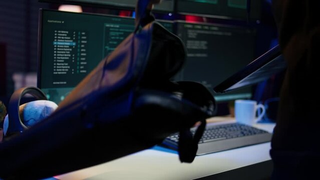 Hacker arriving in underground HQ with laptop in suitcase, ready to start coding malware. Cybercriminal opening notebook to exploit network backdoors and bypass security measures, close up, camera B