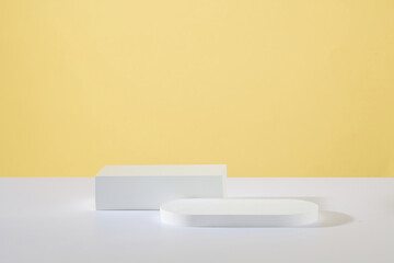 Minimal scene concept with two podiums in different geometric shapes featured over yellow background. Pastel minimal wall scene collection. Modern platform for product display presentation