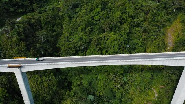 cars drive along a high bridge over an abyss. the high bridge among tropical mountains. Agas Agas bridge