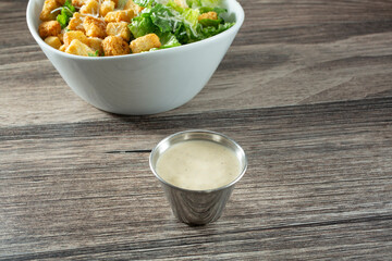 A view of Caesar dressing in a metal condiment cup.