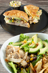 A view of a Southwestern chicken sandwich, next to a Southwestern chicken salad.