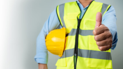 Civil engineer architect standing holding a safety helmet on grey background, Construction site...