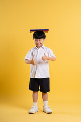 Portrait of adorable asian boy posing on yellow background