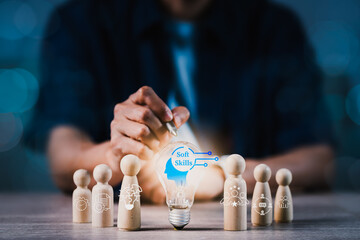 A man is pointing at a light bulb on a table with wooden figurines