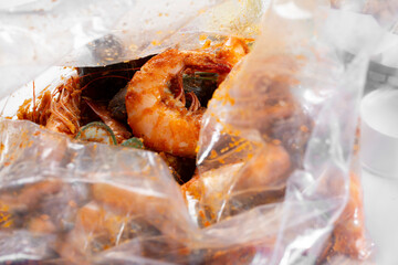 A closeup view of a plastic bag of seafood boil.