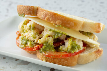 A closeup view of a chicken pesto sandwich.