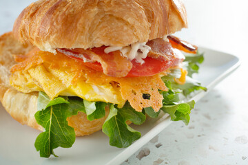 A view of a breakfast croissant sandwich.