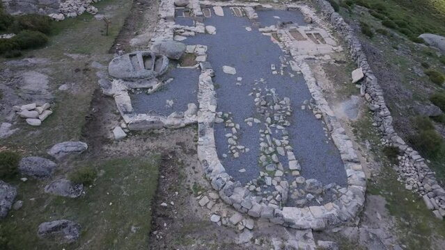 flight with a drone over the archaeological remains of a Visigoth church 6th-7th centuries AD where there are tombs inside the structure, outside we see areas excavated by archaeologists in Avila