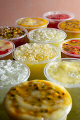 A view of several cups of flavored sugarcane juice.