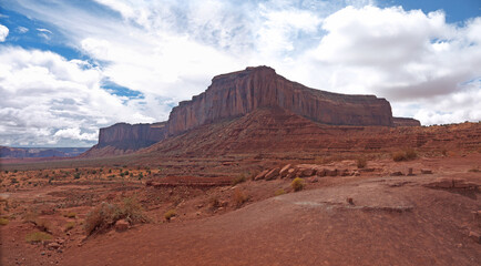 Monument Valley panorama with famous Mitchell mesa, driving by Loop road, nice clouds above