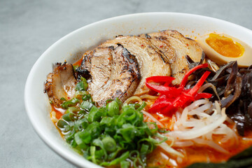 A closeup view of a bowl of spicy tonkatsu ramen.