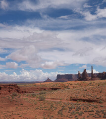 Monument Valley red desert landscape in sunny day, Totem Pole and Yei Bi Chei in background, nice clouds above