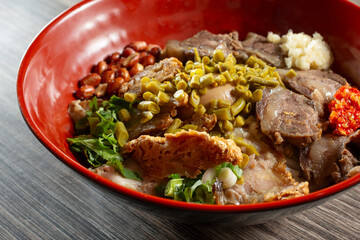 A closeup view of a bowl of crispy pork and beef ribs rice noodles.