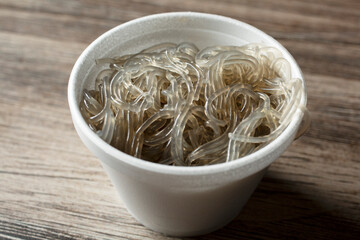 A closeup view of a cup full of glass noodles.