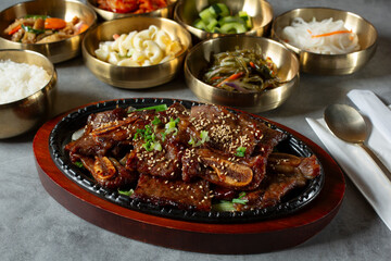 A view of a plate of galbi, surrounded by assorted banchan.