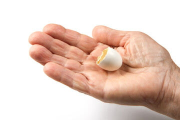 Eggshell in the hand of an elderly woman. A chick hatched from the egg.