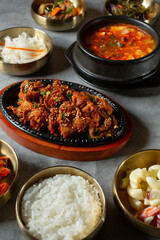 A view of spicy pork bulgogi and soon tofu, among several banchan bowls.