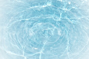 Blue water with ripples on the surface. Defocus blurred transparent blue colored clear calm water surface texture with splashes and bubbles. Water waves with shining pattern texture background.	