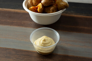 A view of a plastic condiment cup of aioli.