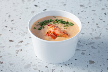 A closeup view of a cup of lobster bisque.