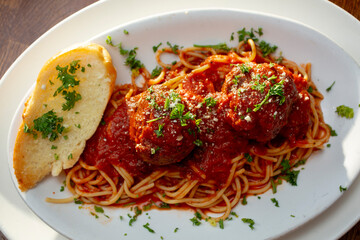 A top down view of a plate of spaghetti and meatballs.