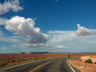 Bikers riding to Monument valley on lonely Arizona red desert road on sunny day as getting away form it all concept
