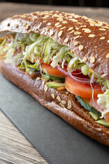 A closeup view of a vegan sandwich on a squaw-roll.