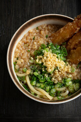 A top down view of a bowl of shrimp tempura udon.