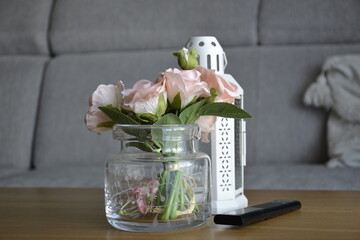 Bukiet kwiatów w wazonie na stoliku kawowym w salonie © VILKTERIO