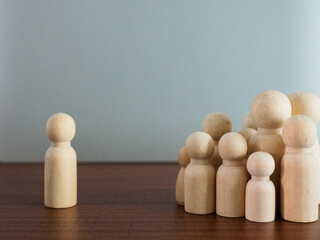 Group of wooden puppets in a meeting or selection of leaders on a gray background