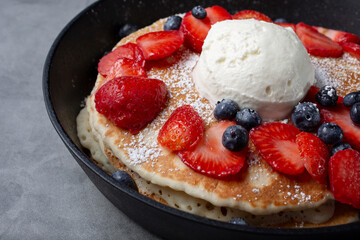 A view of a skillet of fruit pancakes.