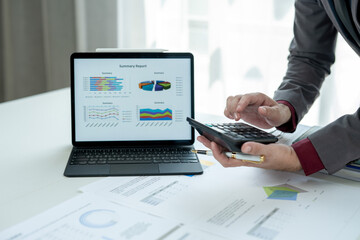 A man is looking at a laptop with a summary report on it