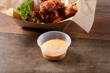 A view of a plastic condiment cup of sriracha mayo sauce.